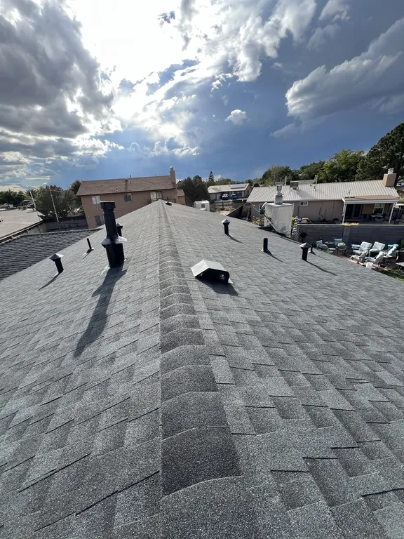 Back slope of the new roof with ridge cap and flashed vent pipes