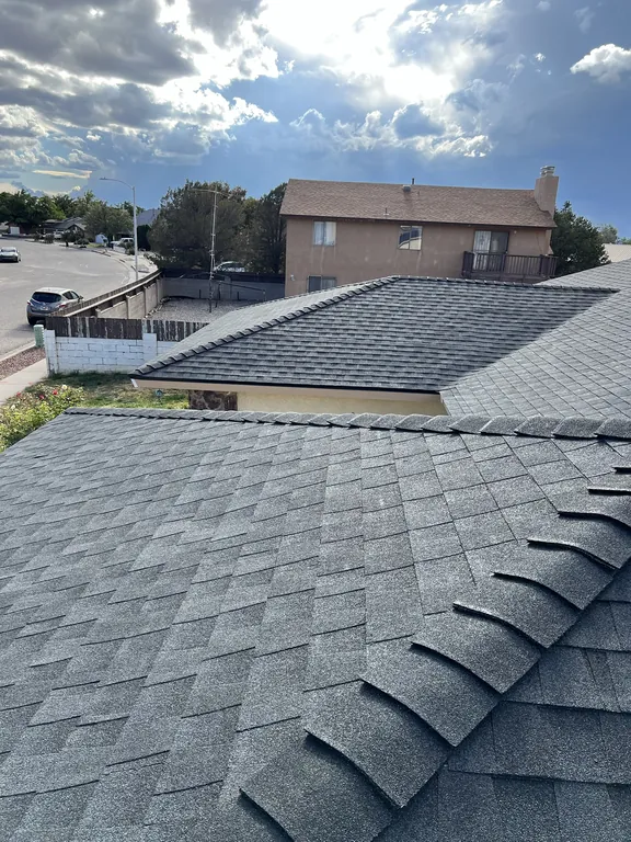 Finished hip roof corner and attached garage roof with new dark gray shingles