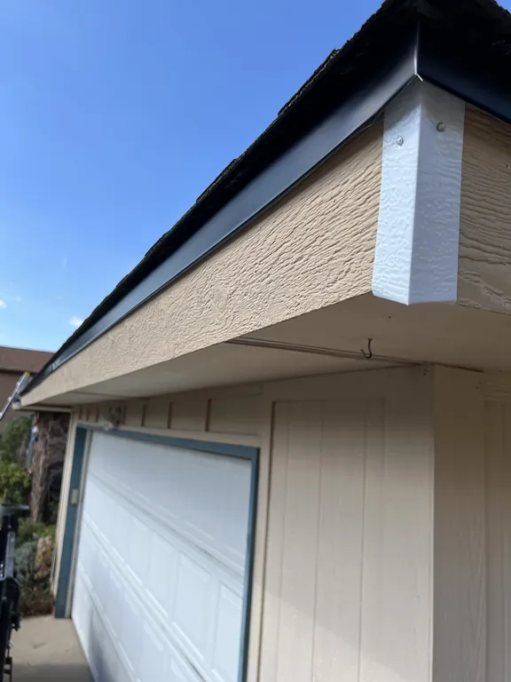 New black metal drip edge installed along the eave above the garage