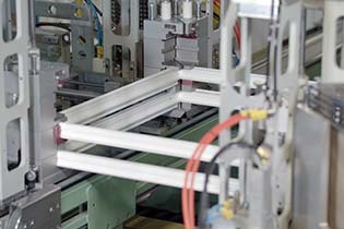 Climate Solutions technician precision-welding a vinyl window frame corner on the factory line