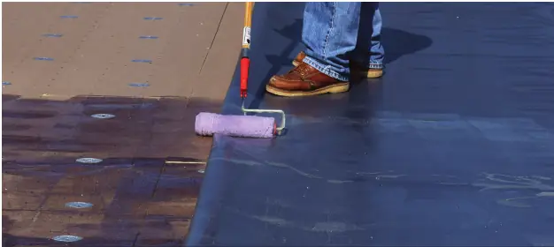 Bonding adhesive being rolled onto the substrate for an adhered TPO roof