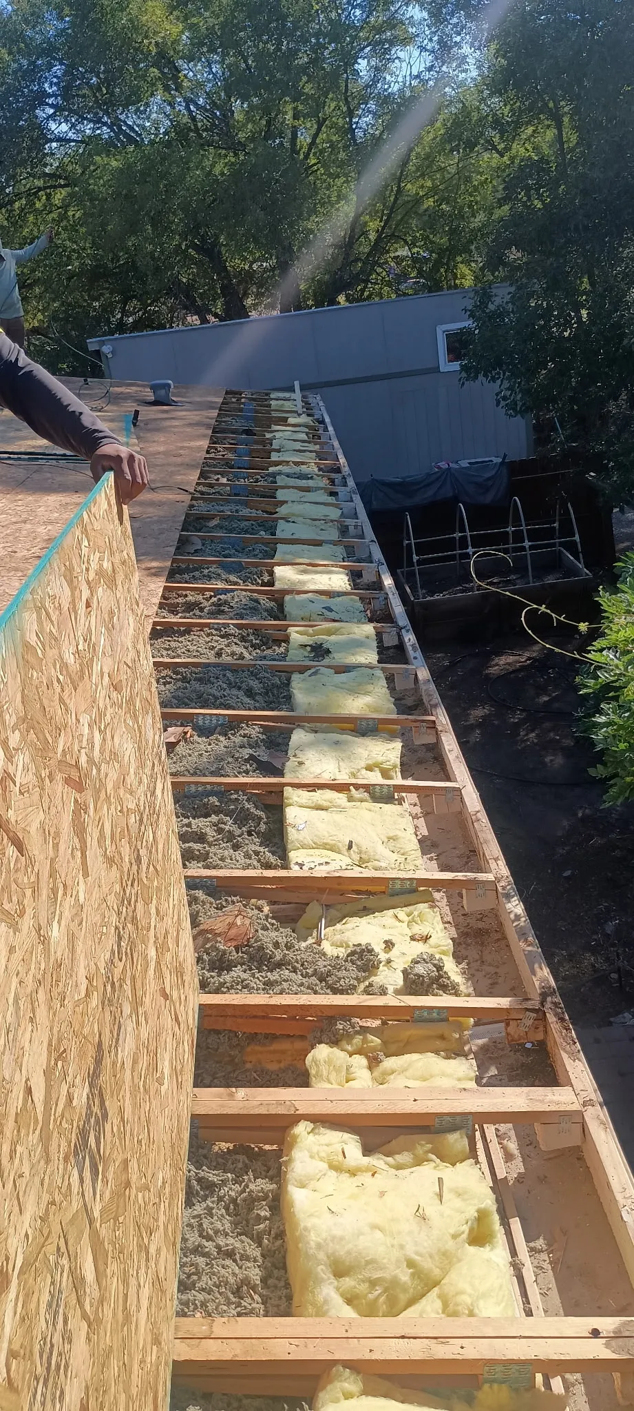 Attic insulation and gutter guard installation along a roofline
