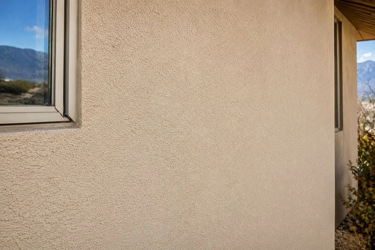Same stucco wall after crack repair, patched and re-textured to match