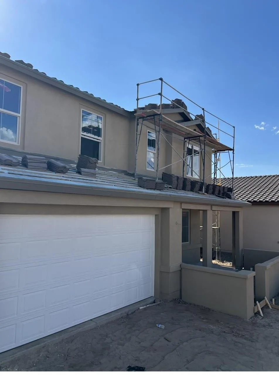 Tile roofing installation in progress on an Albuquerque home, underlayment and tile stacks visible on the roof deck