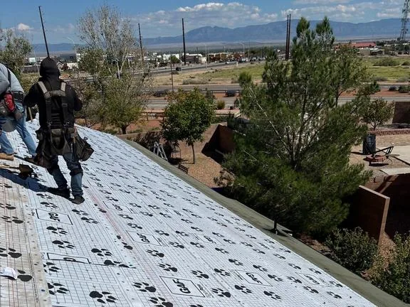 Roofers on fresh GAF Tiger Paw underlayment with the mountains in the background
