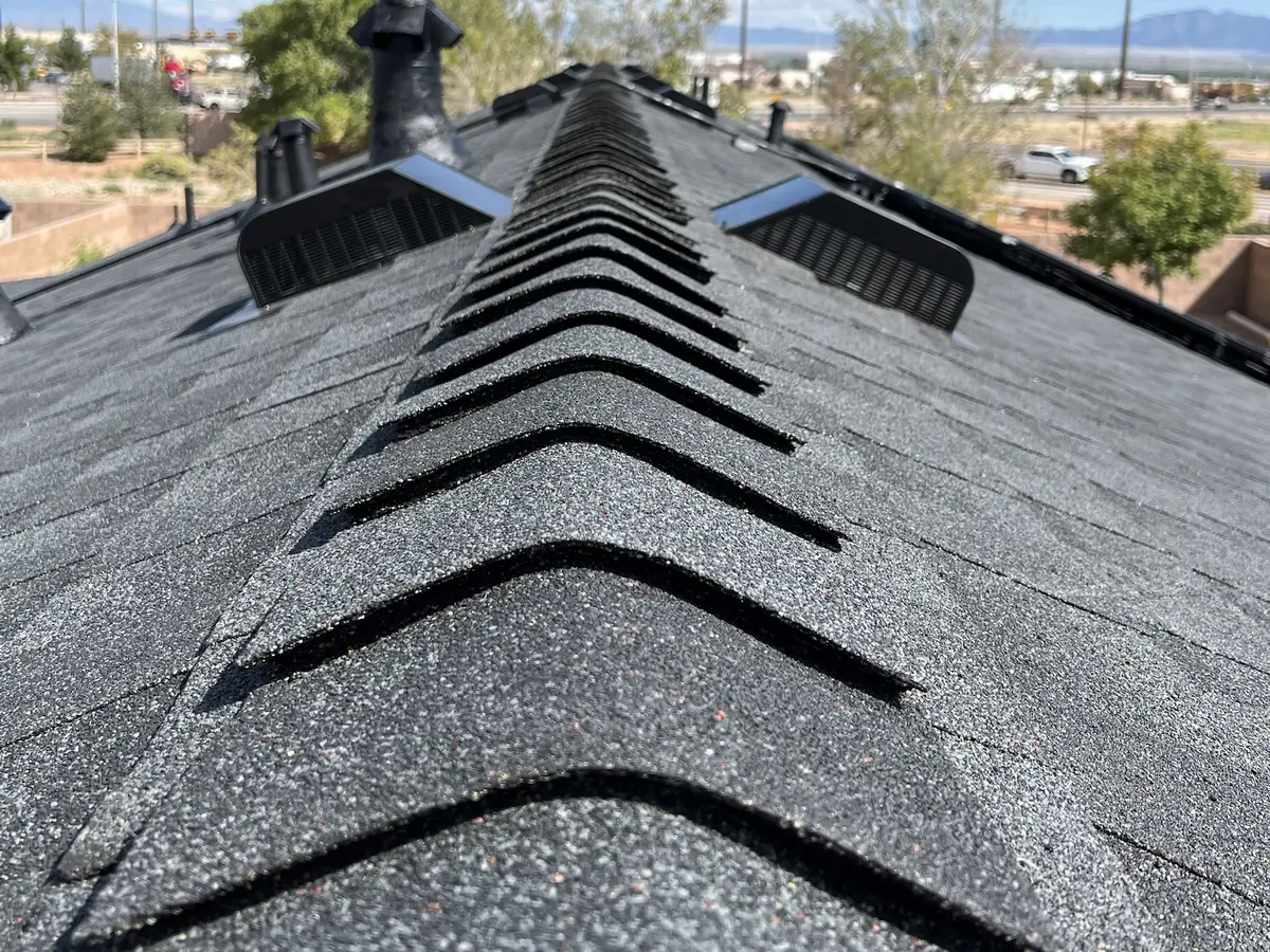 Close-up of new ridge cap shingles on a GAF Timberline NS Charcoal roof