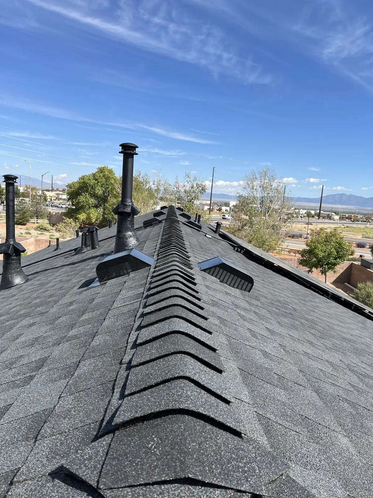 Finished GAF Timberline NS Charcoal shingle roof with new ridge cap and vents on a Los Lunas, NM home