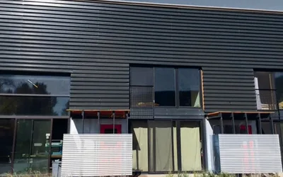 Black 7/8 inch corrugated metal siding on a modern two-story building