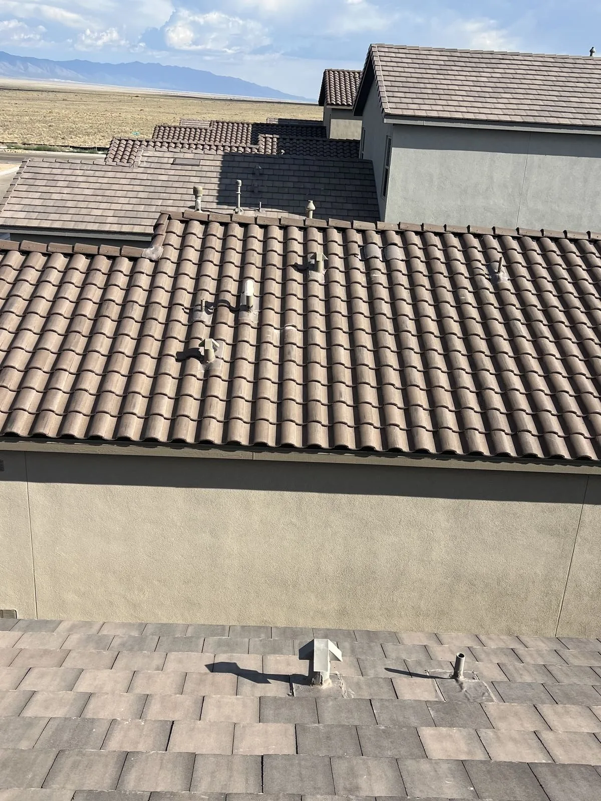 Tile roof replacement in progress with mountain backdrop